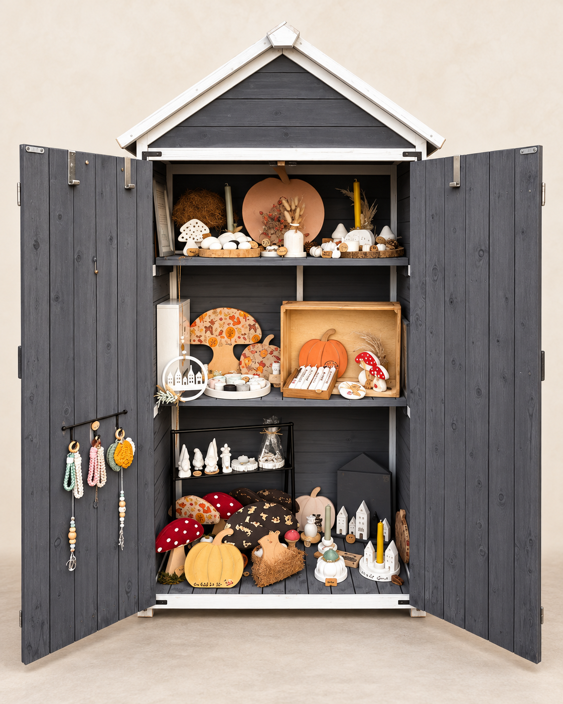 Geöffnetes dunkelgraues Verkaufshäuschen mit weißen Türenrahmen und liebevoll arrangierten Dekoartikeln, Wichteln, Häuschen, Pilzen und herbstlichen Motiven