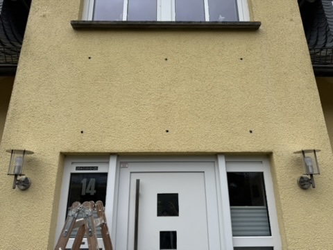 Nahaufnahme der vorbereiteten Befestigungspunkte an der Fassade über der Haustür